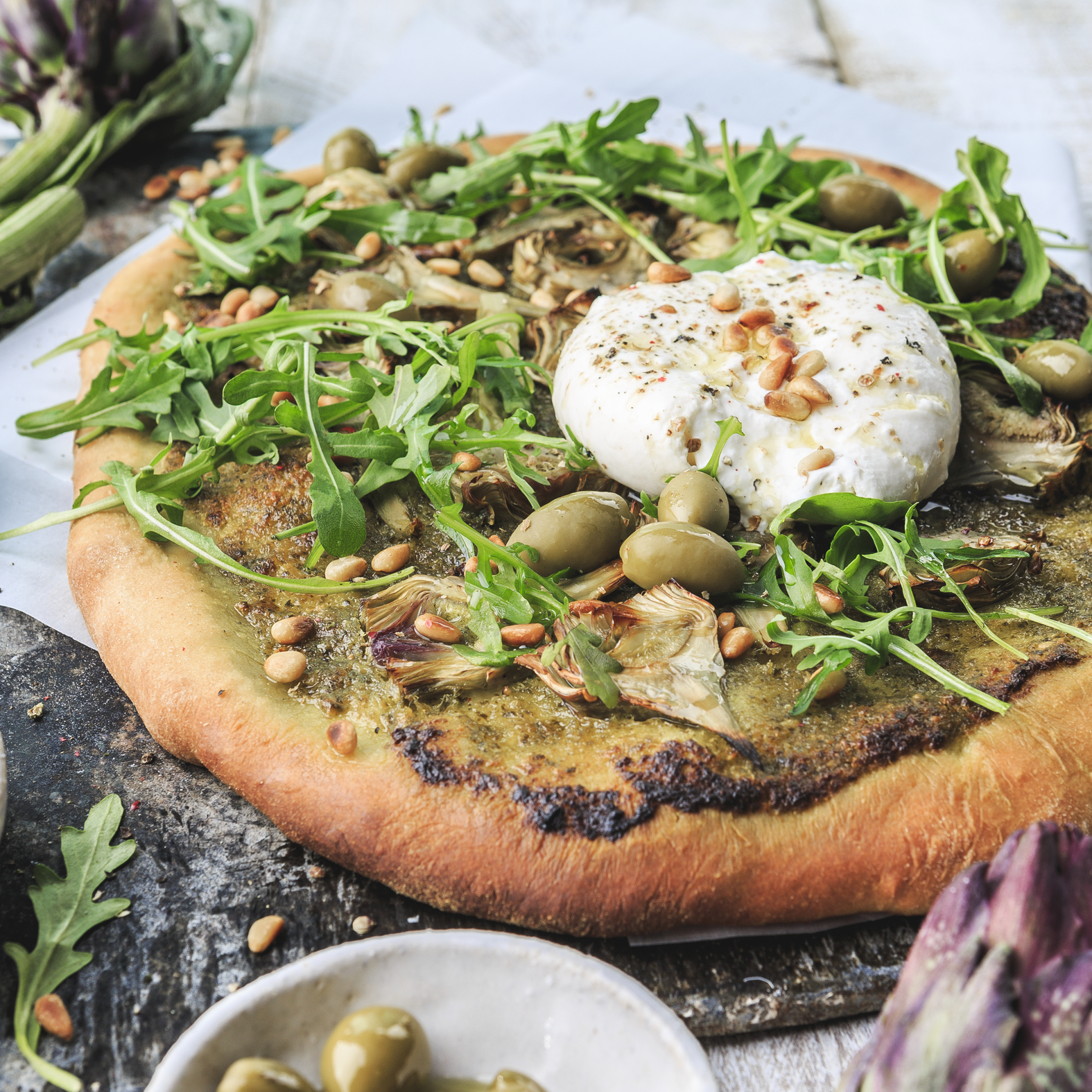 Pizza de pesto con burrata y alcachofas