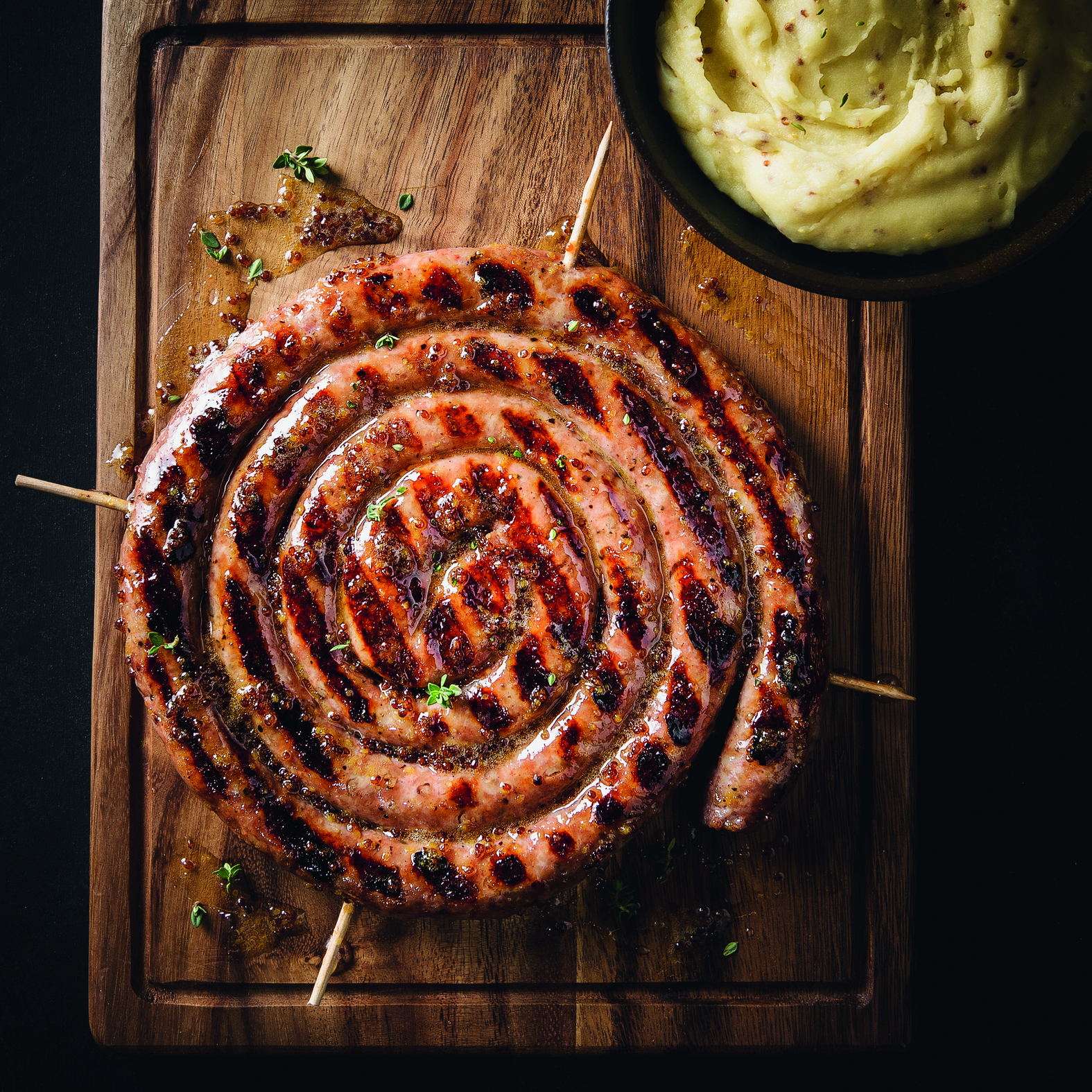 Ristra de salchichas a la parrilla cubierta de mostaza