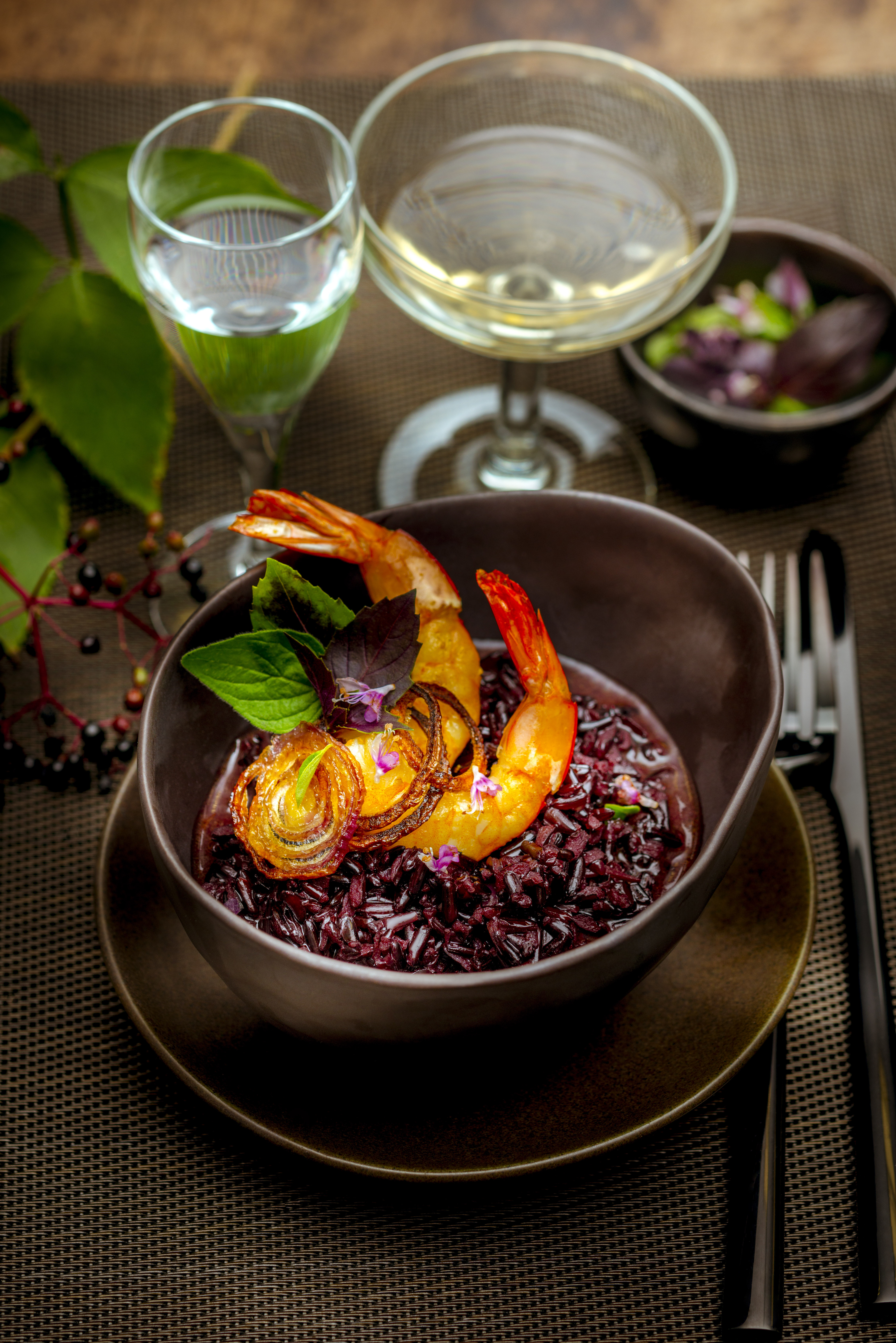 Risotto de arroz negro, gambas y cebolla roja confitada